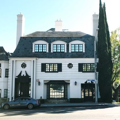 A white building with a slate mansard roof on Sunset Boulevard.